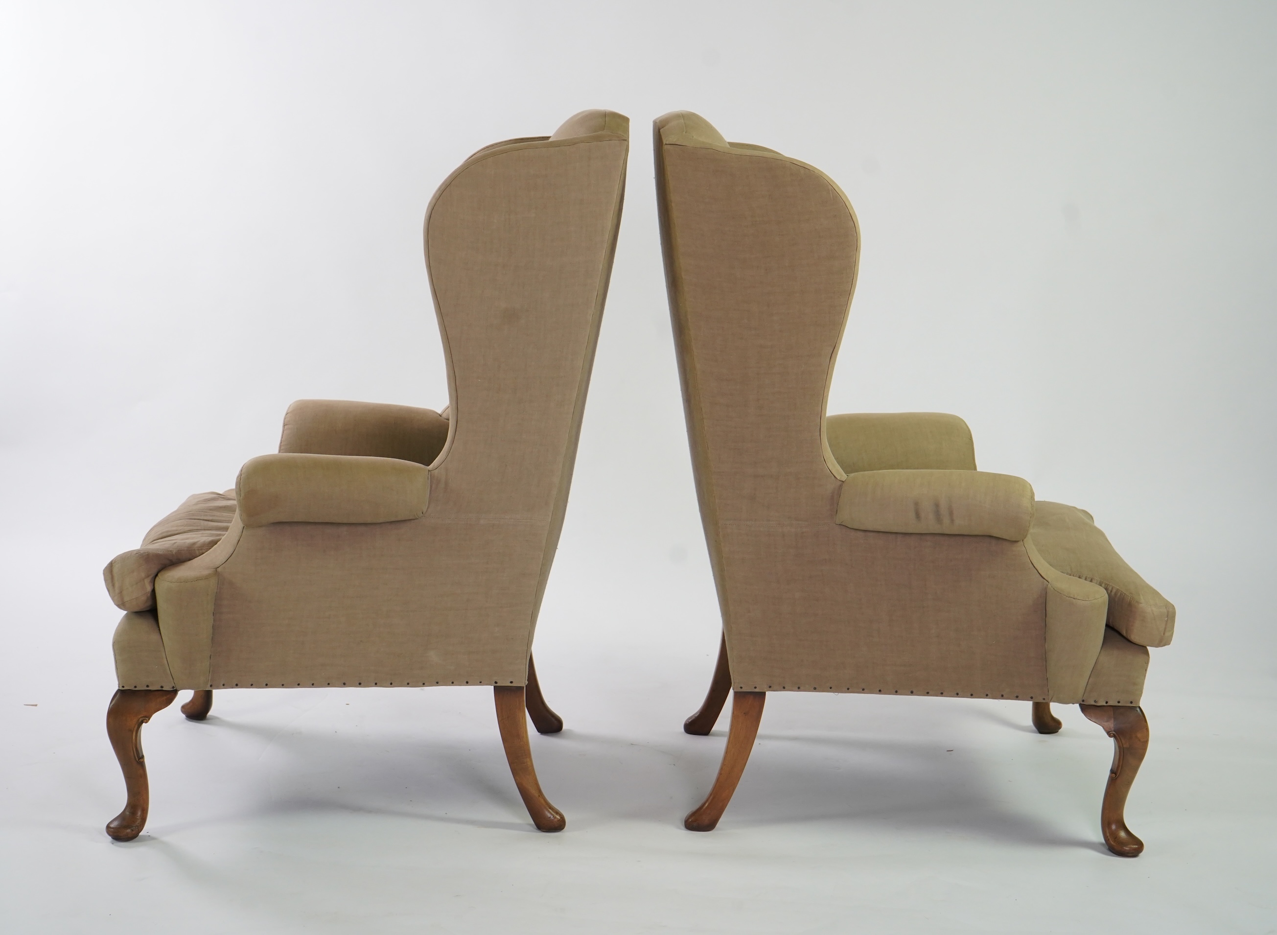 A pair of late 19th / early 20th century George II style upholstered wing armchairs
